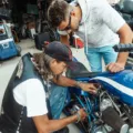 Mekanik sedang merawat mesin untuk cara mengatasi motor susah starter