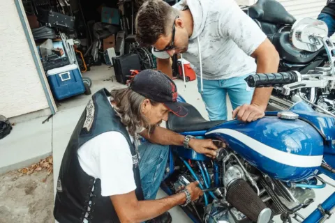 Mekanik sedang merawat mesin untuk cara mengatasi motor susah starter