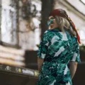 Model mengenakan inspirasi gaya bohemian dengan gaun maxi bermotif etnik dan aksesoris berumbai