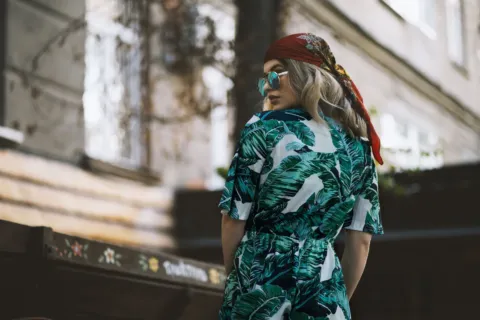 Model mengenakan inspirasi gaya bohemian dengan gaun maxi bermotif etnik dan aksesoris berumbai