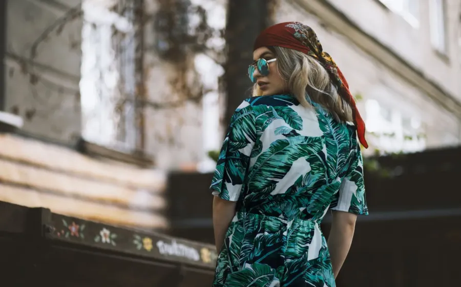 Model mengenakan inspirasi gaya bohemian dengan gaun maxi bermotif etnik dan aksesoris berumbai