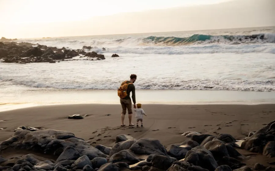 Ibu dan anak kecil sedang menikmati tips liburan dengan anak kecil yang santai di taman pantai