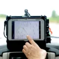 Perangkat alat pelacak kendaraan GPS tracker yang terpasang pada dashbor mobil
