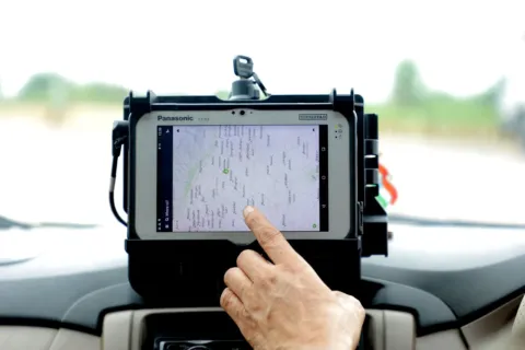 Perangkat alat pelacak kendaraan GPS tracker yang terpasang pada dashbor mobil