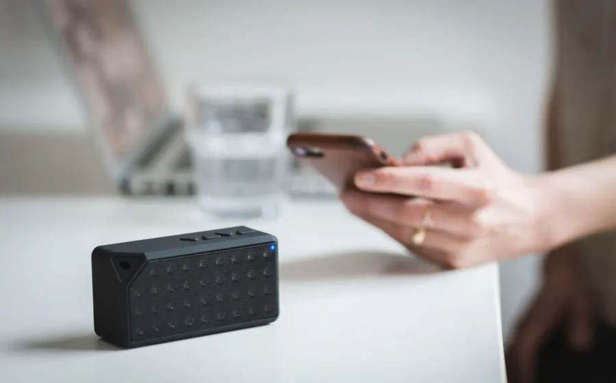 Ilustrasi speaker Bluetooth portabel bersuara jernih sedang memutar musik di meja kerja