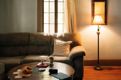 Konsep tips mengatur pencahayaan rumah modern dengan lampu warm white di ruang tamu yang estetik