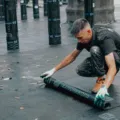 Tukang bangunan sedang memperbaik bagian atap rumah bocor menggunakan cat waterproofing